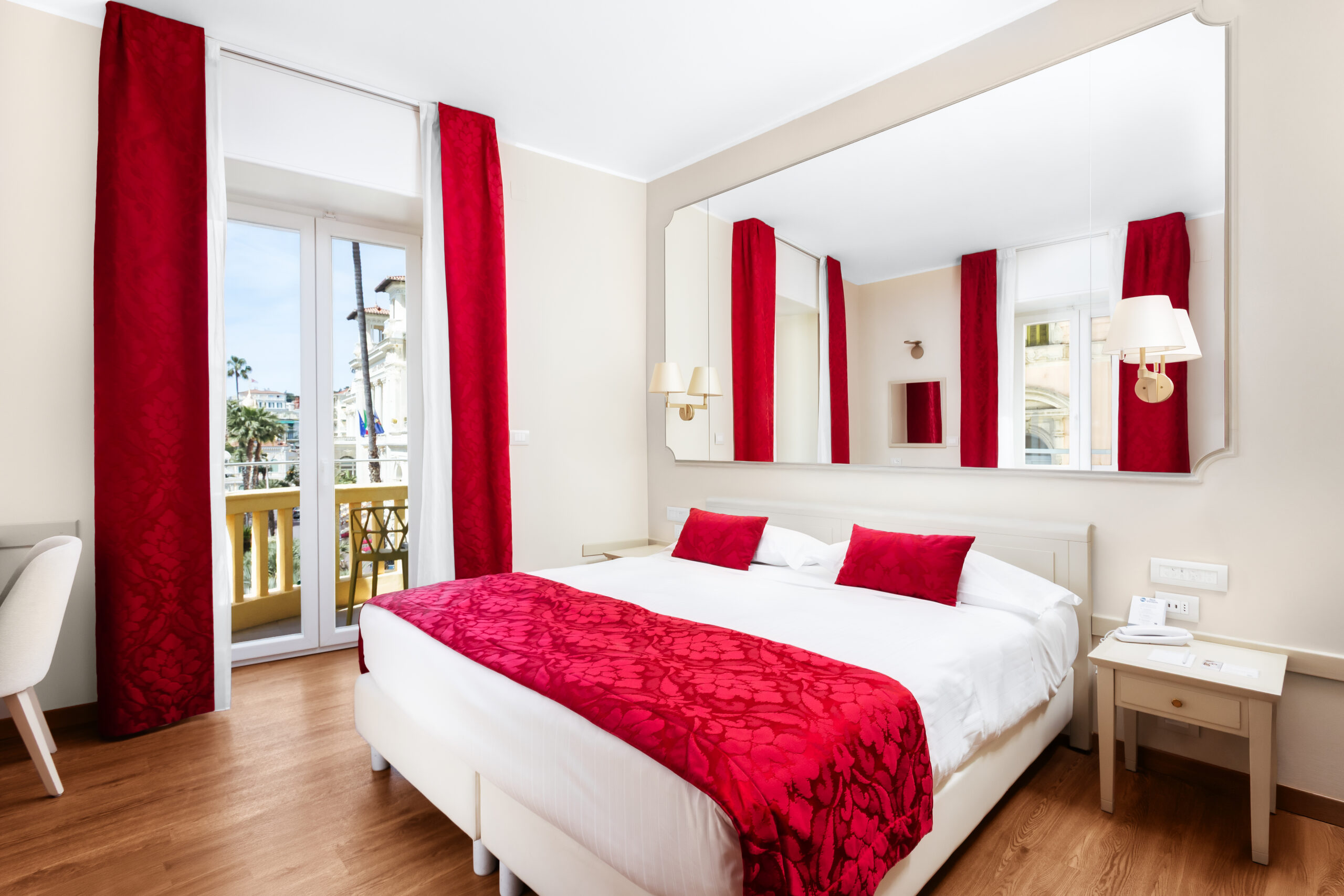 The image shows a double bedroom with French windows and a small balcony.