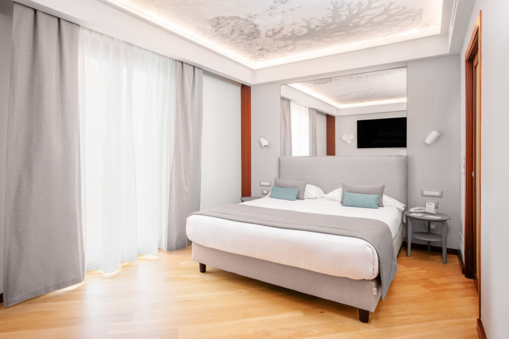 The image shows a room with a window and a double bed.