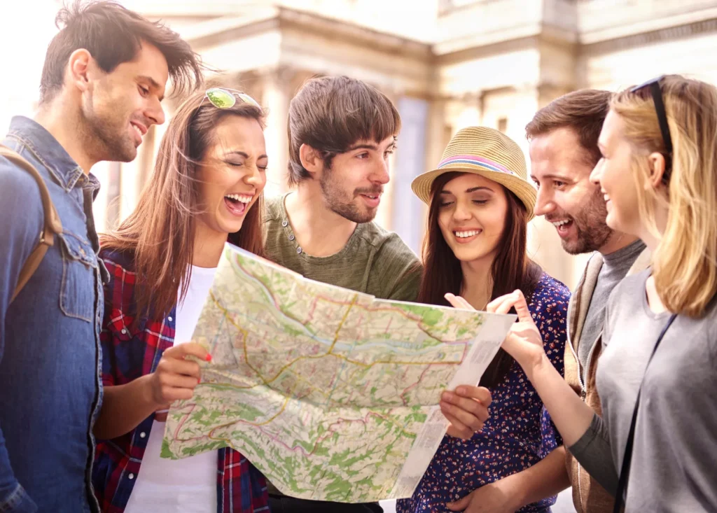 In the image, five young people holding a map